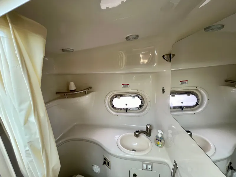 Slide: The Image of 2005 Sea Ray Amberjack 290 bathroom with sink, mirror, and porthole window. - 13