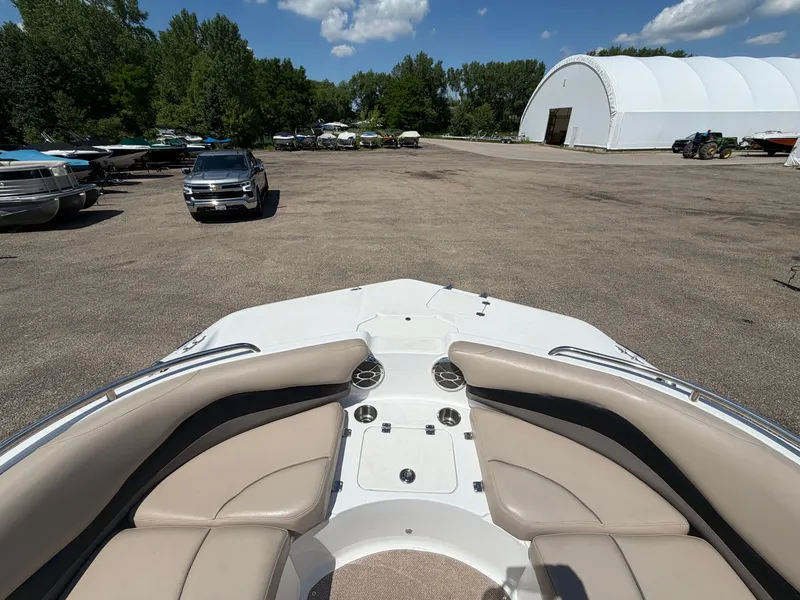 Slide: The Image of Hurricane 202 Sundeck Sport 2014 on parking lot with vehicles and storage building. - 17