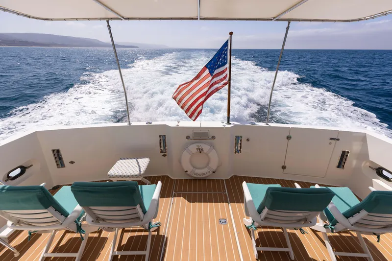 Slide: The Image of 1997 West Bay Sonship yacht deck with chairs, American flag, ocean view. - 13