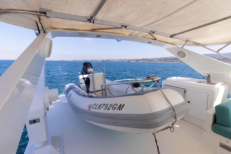 Slide: The Image of 1997 West Bay Sonship yacht with dinghy on deck, overlooking serene ocean view. - 17