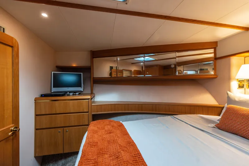 Slide: The Image of Luxurious 1997 West Bay Sonship yacht bedroom with TV, wooden cabinetry, and cozy bedding. - 44