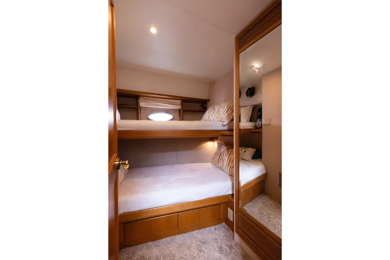 Slide: The Image of Cozy bunk beds in 1997 West Bay Sonship yacht cabin, featuring wood accents and soft lighting. - 45