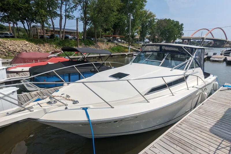 The Image of 1995 Wellcraft 330 Coastal boat docked at a marina with scenic background. - 0