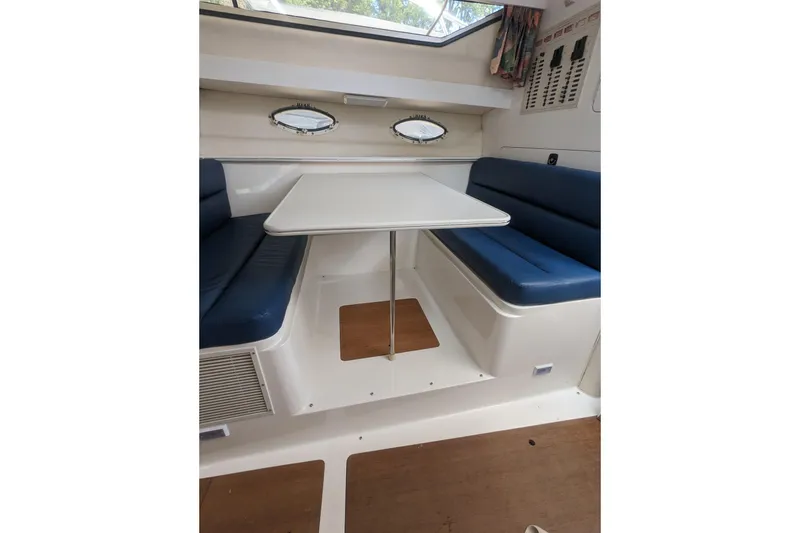 Slide: The Image of 1995 Wellcraft 330 Coastal cabin interior with blue seating and white table. - 13