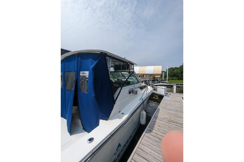 Slide: The Image of 1995 Wellcraft 330 Coastal boat docked with blue canopy and clear sky. - 15