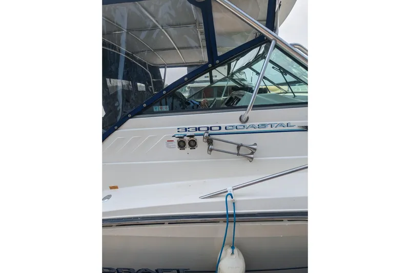 Slide: The Image of 1995 Wellcraft 330 Coastal boat side view with canopy and railing details. - 16
