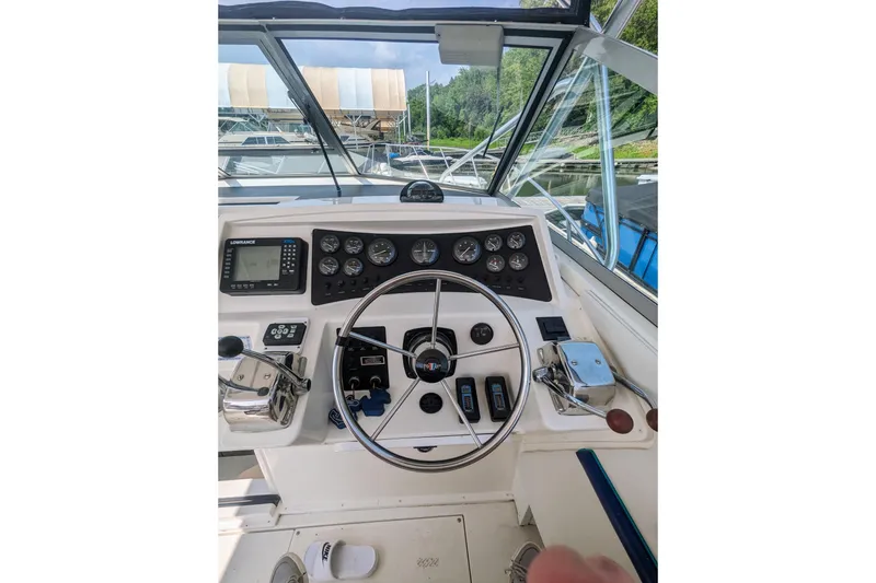 Slide: The Image of 1995 Wellcraft 330 Coastal helm with steering wheel, gauges, and navigation equipment. - 17