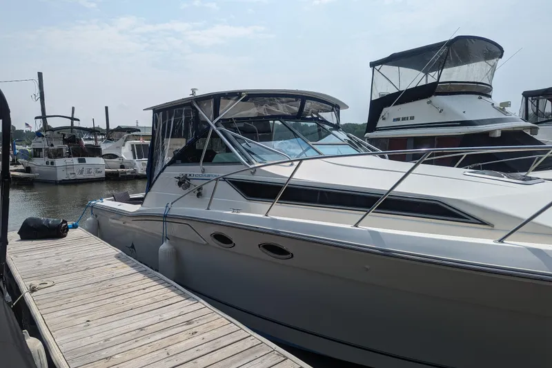 Slide: The Image of 1995 Wellcraft 330 Coastal boat docked at marina, surrounded by other vessels. - 2