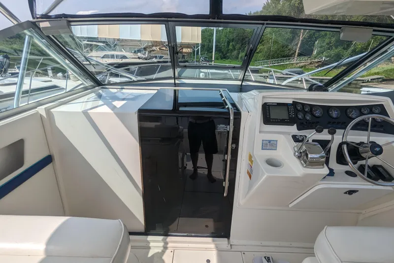 Slide: The Image of 1995 Wellcraft 330 Coastal boat cockpit with steering wheel and control panel. - 20