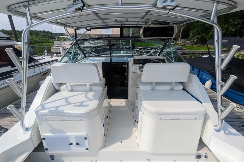 Slide: The Image of 1995 Wellcraft 330 Coastal boat interior with white seating and fishing rod holders. - 22