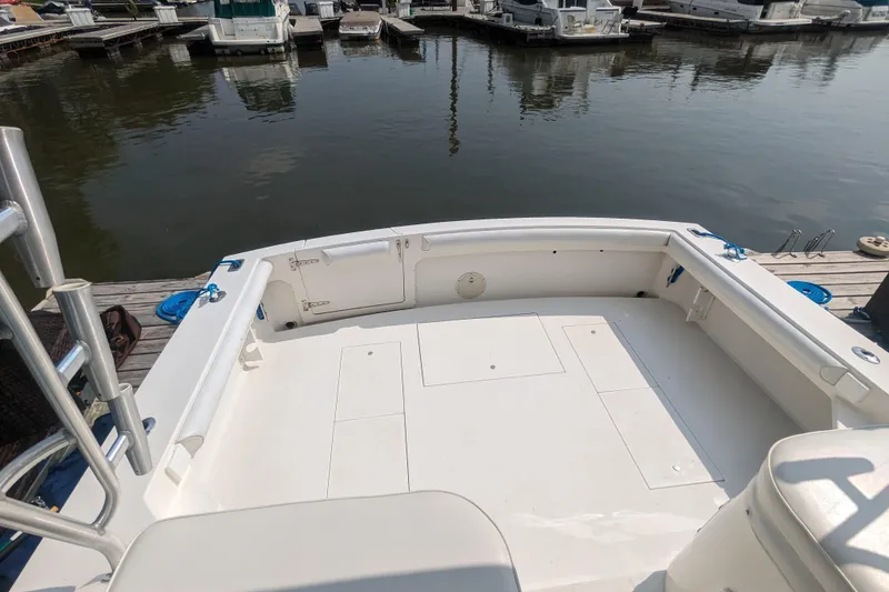 Slide: The Image of 1995 Wellcraft 330 Coastal boat deck at marina, featuring spacious seating and storage. - 23