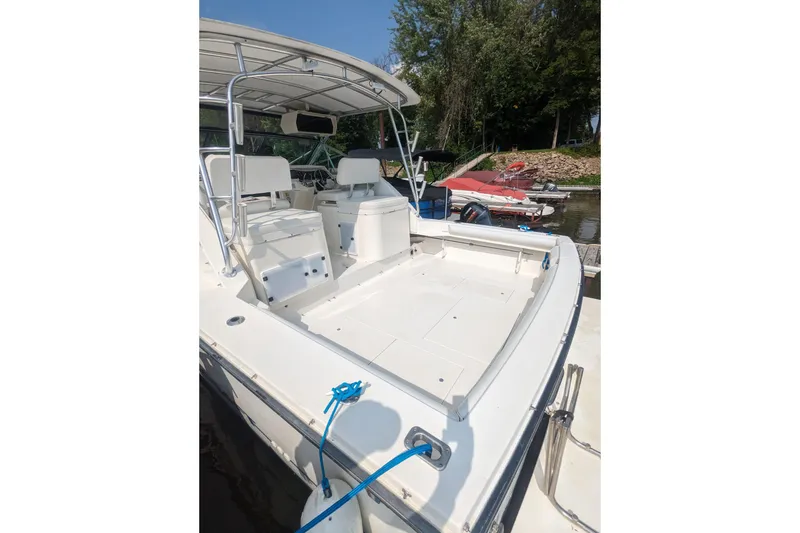 Slide: The Image of 1995 Wellcraft 330 Coastal boat docked, featuring spacious deck and seating area. - 25