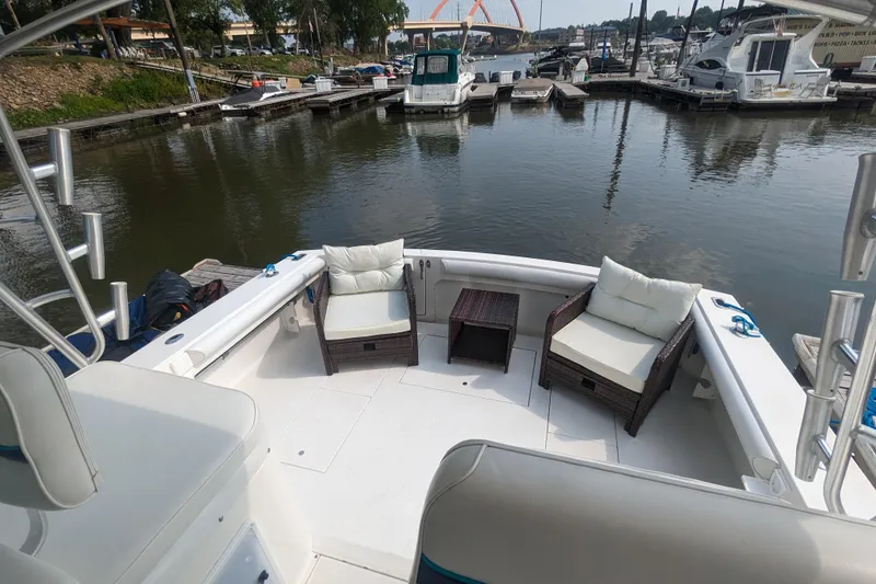 Slide: The Image of 1995 Wellcraft 330 Coastal boat interior with cushioned seating at a marina. - 27