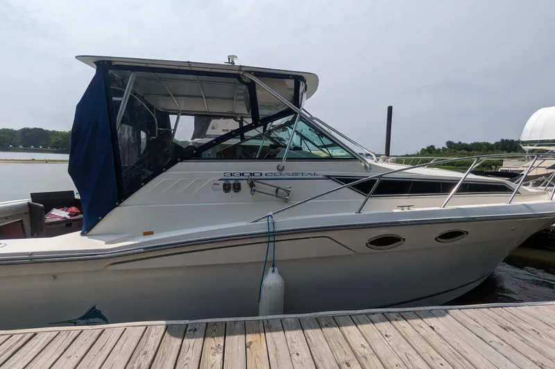 Slide: The Image of 1995 Wellcraft 330 Coastal boat docked at marina, side view with canopy. - 3