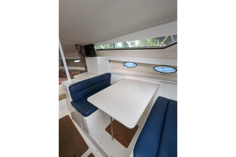 Slide: The Image of Interior of 1995 Wellcraft 330 Coastal boat with blue seating and white table. - 7