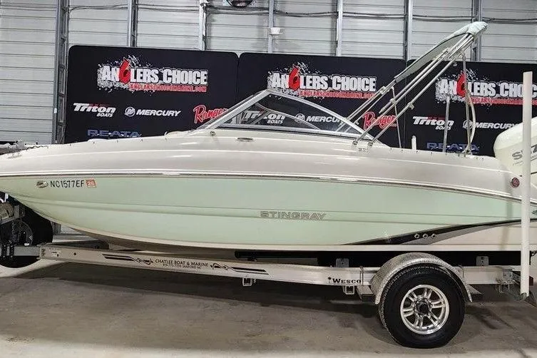 Slide: The Image of 2017 Stingray 201 DC boat on trailer in showroom with Anglers Choice banners. - 0