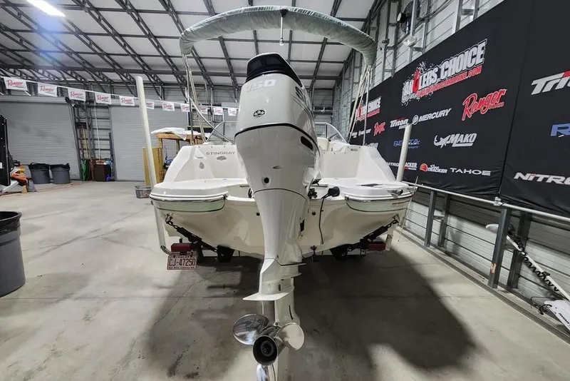 Slide: The Image of 2017 Stingray 201 DC boat in a showroom, featuring a powerful outboard motor. - 1