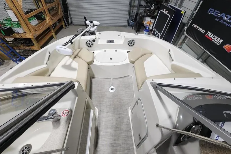Slide: The Image of 2017 Stingray 201 DC boat interior with beige seating and modern dashboard. - 4