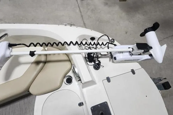 Slide: The Image of 2017 Stingray 201 DC boat with trolling motor on deck, featuring beige seating and storage compartments. - 6