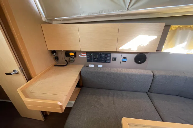 Slide: The Image of Interior of 2015 Beneteau First 235 sailboat with wooden cabinetry and gray seating. - 22