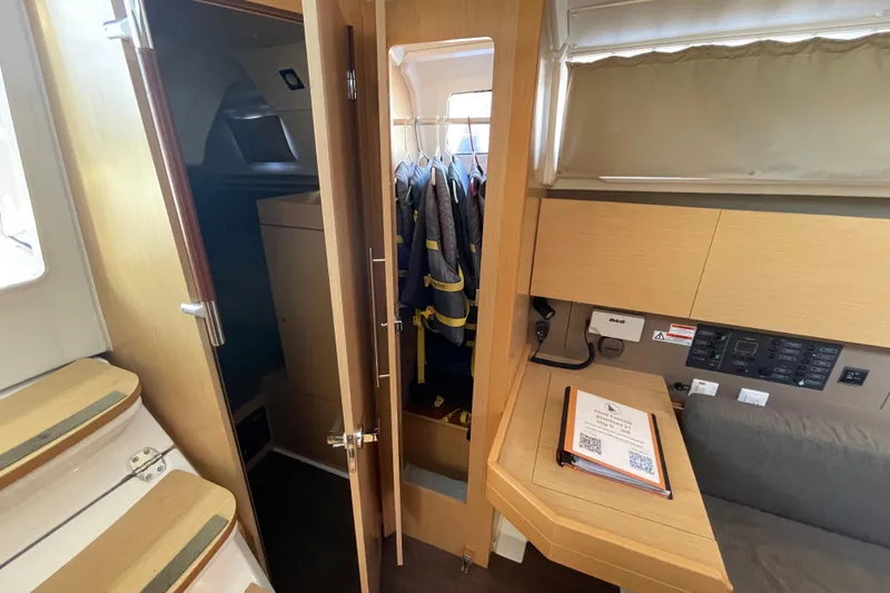Slide: The Image of Interior of 2015 Beneteau First 235 sailboat with wooden cabinetry and navigation station. - 27