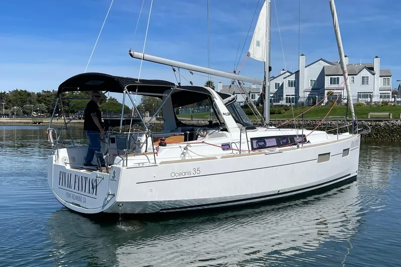 Slide: The Image of A Beneteau Oceanis 35 sailboat named "Final Fantasy" on calm water near houses. - 8
