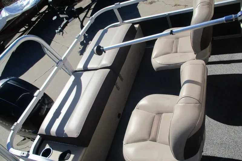 Slide: The Image of 2026 Sun Tracker Fishin' Barge 24 DLX interior with beige seating and railing. - 5