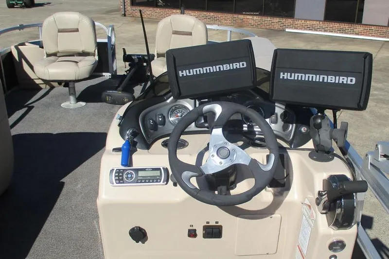 Slide: The Image of 2026 Sun Tracker Fishin' Barge 24 DLX dashboard with dual Humminbird displays and steering wheel. - 6