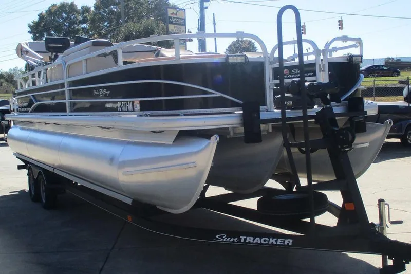 Slide: The Image of 2026 Sun Tracker Fishin' Barge 24 DLX pontoon boat on trailer in outdoor setting. - 7
