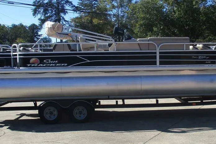 Slide: The Image of 2026 Sun Tracker Fishin' Barge 24 DLX pontoon boat on trailer, outdoors. - 9