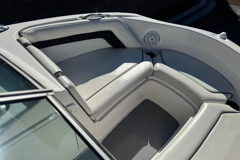 Slide: The Image of 2015 Yamaha Boats AR190 interior seating with white upholstery and speaker detail. - 12