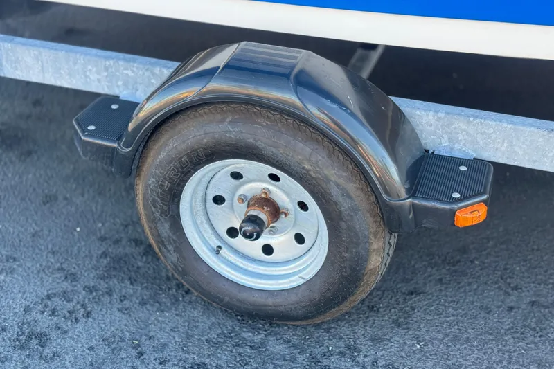 Slide: The Image of Trailer wheel of a 2015 Yamaha Boats AR190, featuring a black fender and orange reflector. - 26