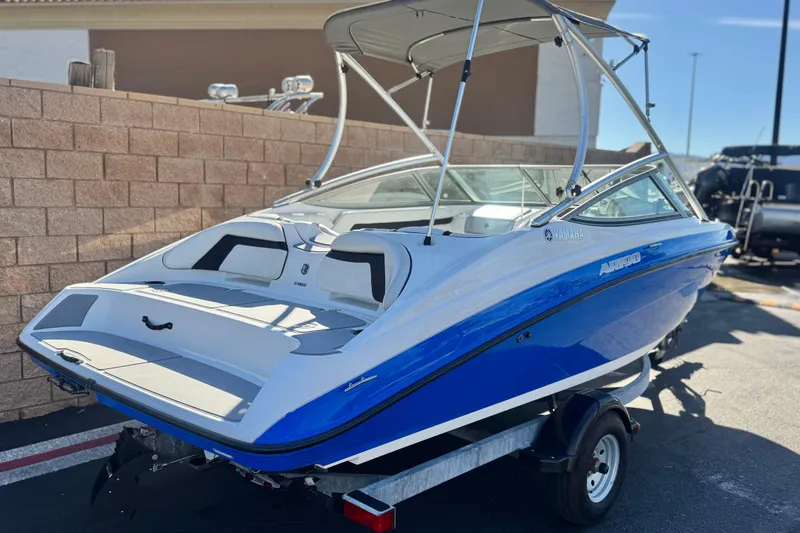 Slide: The Image of 2015 Yamaha Boats AR190, blue and white, on trailer, parked outdoors. - 5