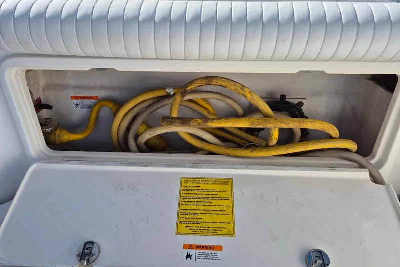 Slide: The Image of Storage compartment with yellow cables in a 2004 Riviera 4000 Offshore boat. - 12