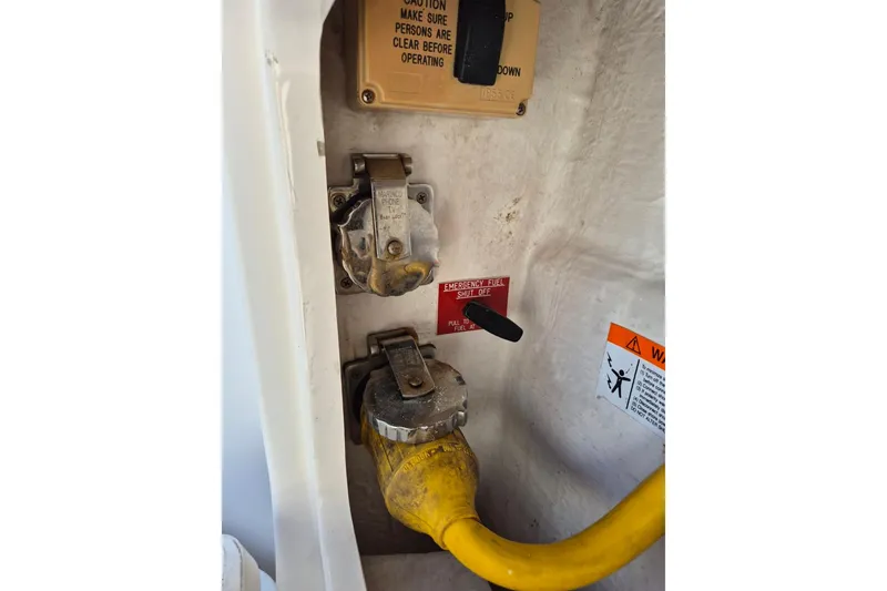 Slide: The Image of 2004 Riviera 4000 Offshore boat electrical panel with yellow cable and emergency fuel shut-off. - 13