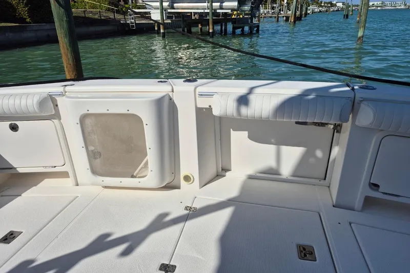 Slide: The Image of 2004 Riviera 4000 Offshore boat deck with seating, docked by calm waters. - 15