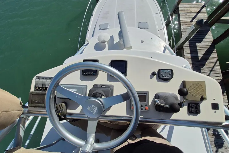 Slide: The Image of 2004 Riviera 4000 Offshore boat helm with steering wheel and control panel. - 19