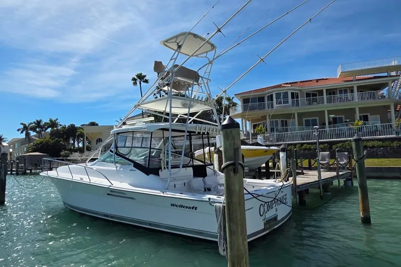 Slide: The Image of 2004 Riviera 4000 Offshore boat docked near waterfront homes under clear blue sky. - 2