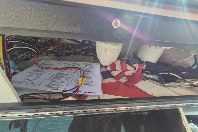 Slide: The Image of Electrical wiring and documents inside a 2004 Riviera 4000 Offshore boat compartment. - 23