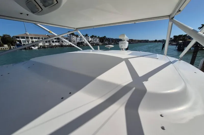 Slide: The Image of 2004 Riviera 4000 Offshore yacht deck with marina view, clear blue sky, and calm waters. - 25