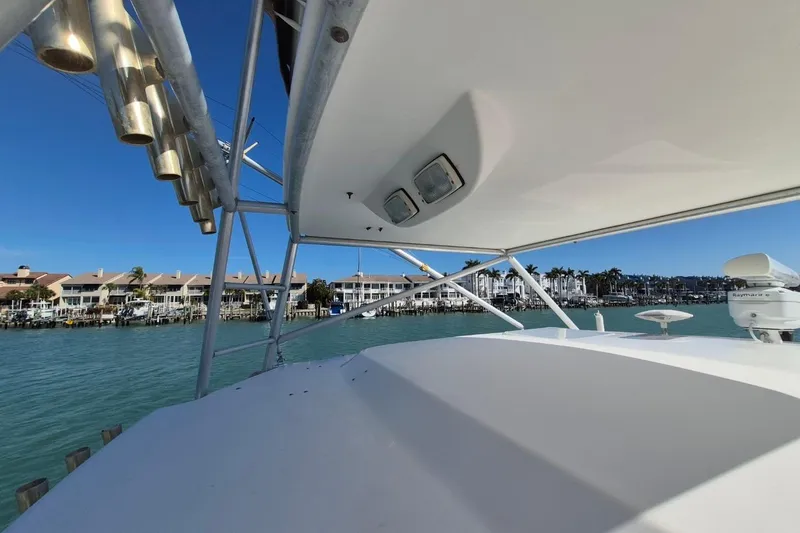 Slide: The Image of 2004 Riviera 4000 Offshore yacht with coastal view and clear blue sky. - 26