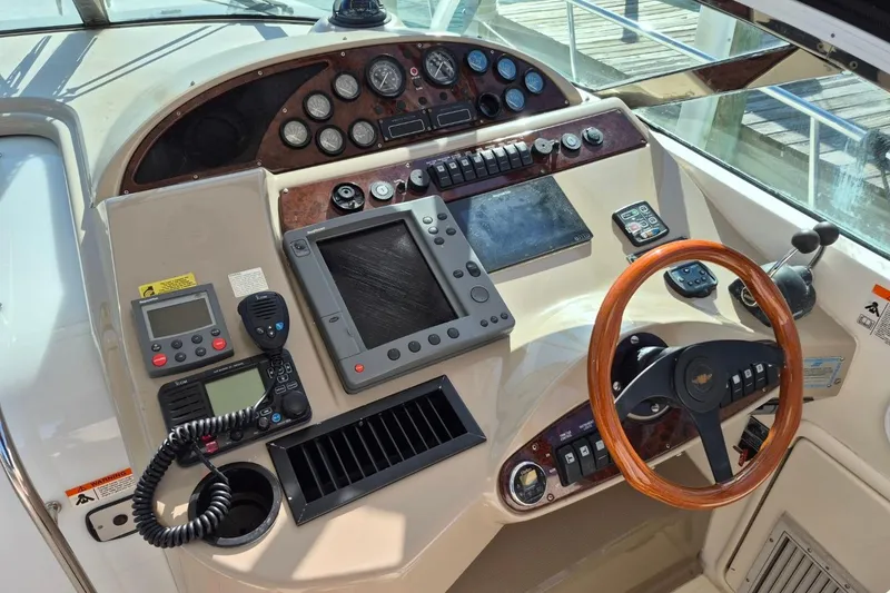 Slide: The Image of Control panel of a 2004 Riviera 4000 Offshore boat with wooden steering wheel. - 27