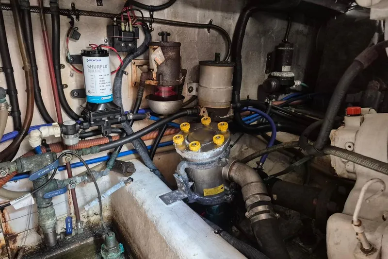 Slide: The Image of Engine room of a 2004 Riviera 4000 Offshore with visible mechanical components and wiring. - 44