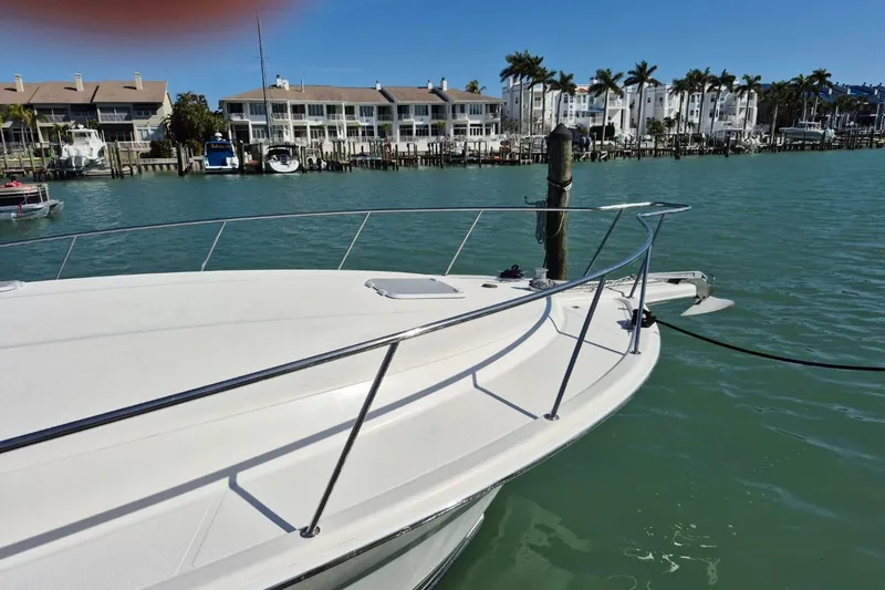 Slide: The Image of 2004 Riviera 4000 Offshore yacht docked in a marina with waterfront buildings. - 5