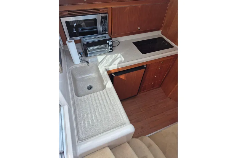 Slide: The Image of 2004 Riviera 4000 Offshore yacht kitchen with sink, microwave, and stove. - 52