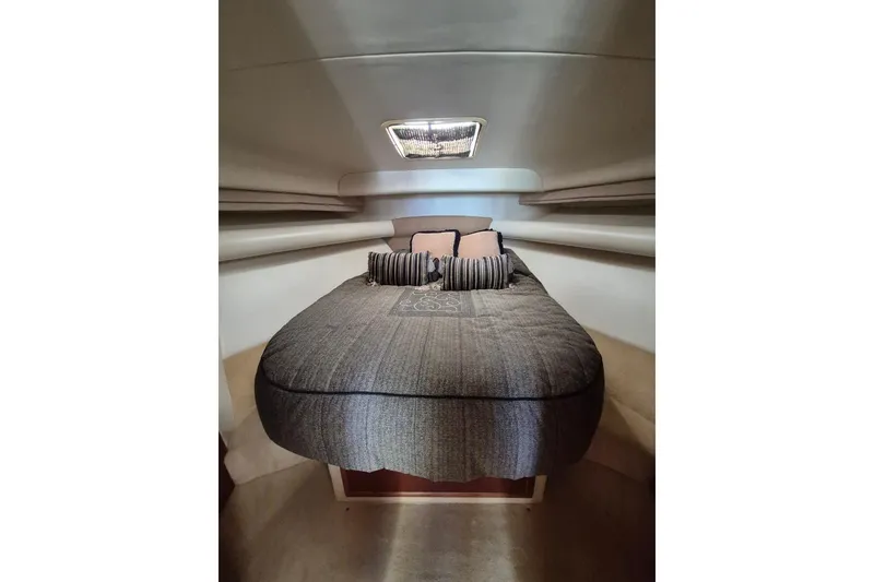 Slide: The Image of 2004 Riviera 4000 Offshore cabin interior with cozy bed and pillows. - 53