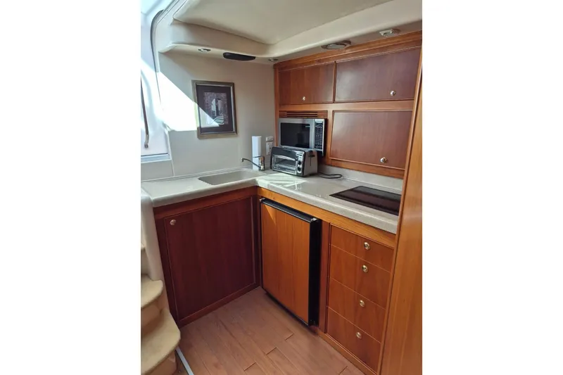 Slide: The Image of 2004 Riviera 4000 Offshore yacht kitchen with wood cabinetry and modern appliances. - 58