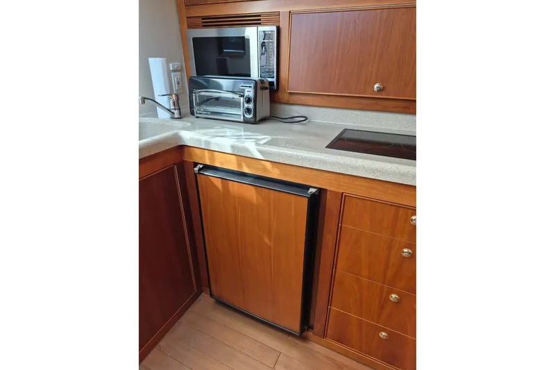 Slide: The Image of 2004 Riviera 4000 Offshore yacht kitchen with wooden cabinetry and modern appliances. - 60