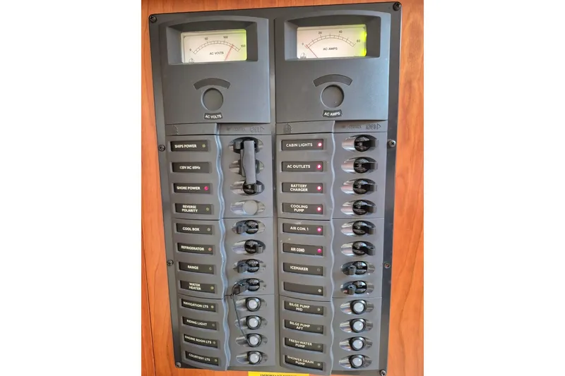 Slide: The Image of Electrical panel of a 2004 Riviera 4000 Offshore boat with labeled switches and meters. - 66