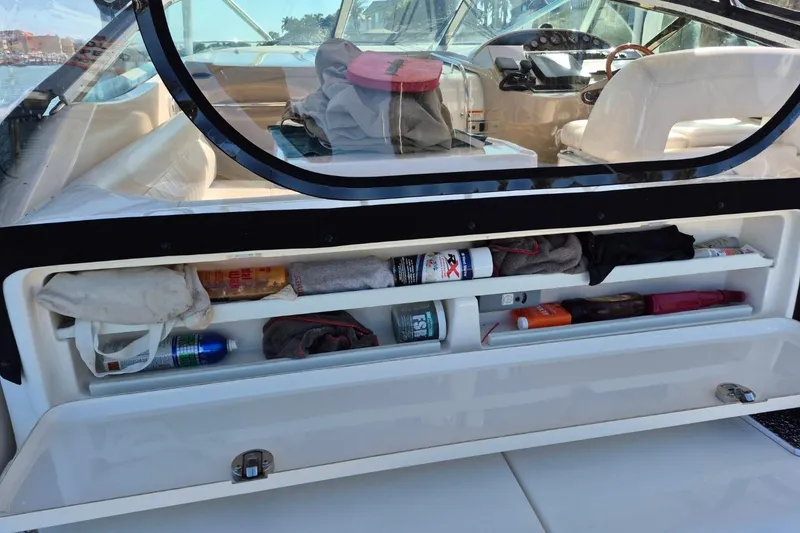 Slide: The Image of Storage compartment on a 2004 Riviera 4000 Offshore boat, containing various items and supplies. - 75